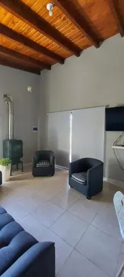 a living room with two black couches and a table at Casa en Potrero de Garay con pileta in Potrero de Garay