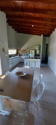 a dining room with a table and chairs and a kitchen at Casa en Potrero de Garay con pileta in Potrero de Garay