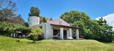 a house on a hill with a dog in front of it at La Calma Casa de Campo - Villa Parque Siquiman in Villa Parque Siquiman