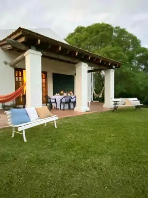 a patio with a hammock and a house at La Calma Casa de Campo - Villa Parque Siquiman in Villa Parque Siquiman