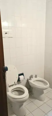 a white bathroom with a toilet and a bidet at La Calma Casa de Campo - Villa Parque Siquiman in Villa Parque Siquiman