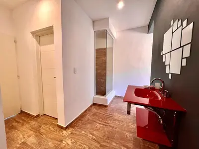a bathroom with a red sink and a mirror at Anubis in Merlo