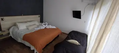 a small bedroom with a bed and a chair at Anubis in Merlo