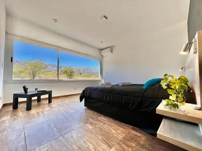 a bedroom with a bed and a large window at Anubis in Merlo