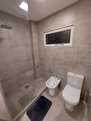 a bathroom with a toilet and a shower and a sink at FRANCISMAR - Cálido Depto. Centro Carlos Paz in Villa Carlos Paz
