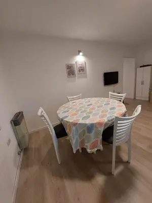 a table and chairs in a room with a table and a television at FRANCISMAR - Cálido Depto. Centro Carlos Paz in Villa Carlos Paz