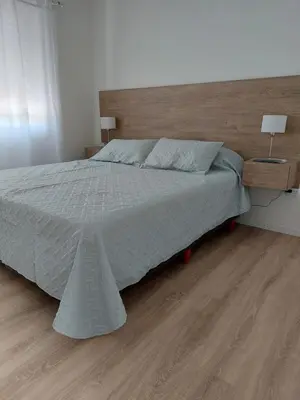 a bedroom with a large bed with a wooden headboard at FRANCISMAR - Cálido Depto. Centro Carlos Paz in Villa Carlos Paz