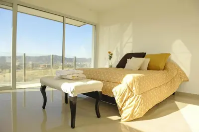 a bedroom with a bed with a table and a window at Villaloma in Villa Carlos Paz