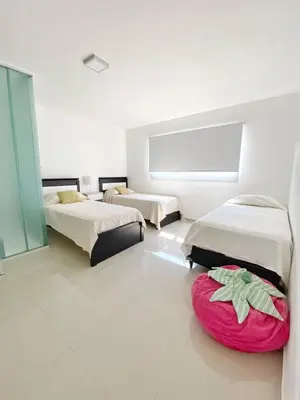 a room with three beds and a red pillow in it at Villaloma in Villa Carlos Paz