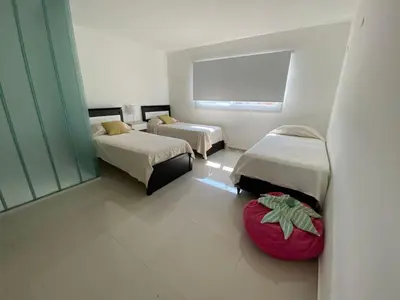 a room with two beds and a red ottoman at Villaloma in Villa Carlos Paz