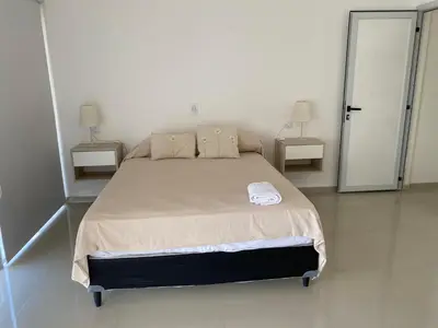 a bedroom with a large bed with two night stands at Villaloma in Villa Carlos Paz