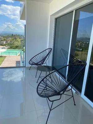 two black chairs sitting on the balcony of a house at Villaloma in Villa Carlos Paz