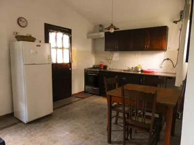a kitchen with a table and a white refrigerator at Descanso Serrano in Tanti