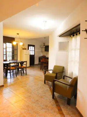 a living room with a table and chairs and a kitchen at Descanso Serrano in Tanti