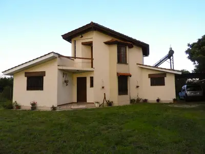 a house on a grassy yard with at Descanso Serrano in Tanti