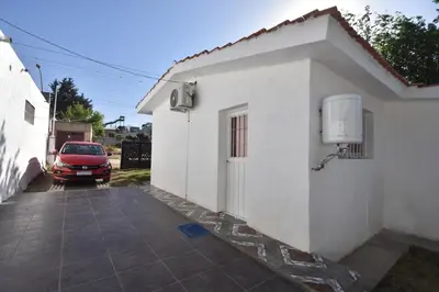 a red car parked next to a white building at Kaiken Maison in Villa Santa Cruz del Lago
