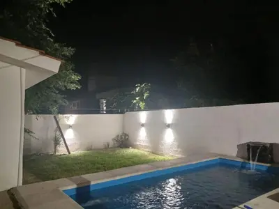a backyard at night with a swimming pool at Kaiken Maison in Villa Santa Cruz del Lago
