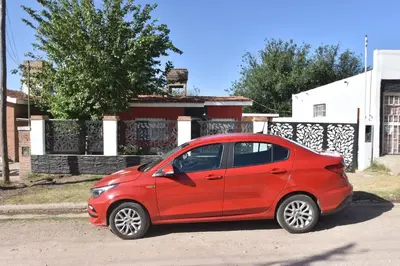 a red small car parked in front of a house at Kaiken Maison in Villa Santa Cruz del Lago
