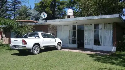 a white truck parked in front of a house at La casita de Calamuchita in Los Reartes
