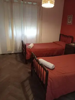 two beds in a room with red walls at La casita de Calamuchita in Los Reartes