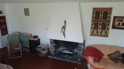 a living room with a fireplace and a couch at La casita de Calamuchita in Los Reartes