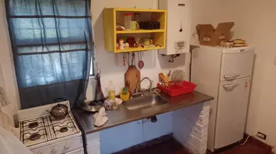 a small kitchen with a sink and a refrigerator at La casita de Calamuchita in Los Reartes