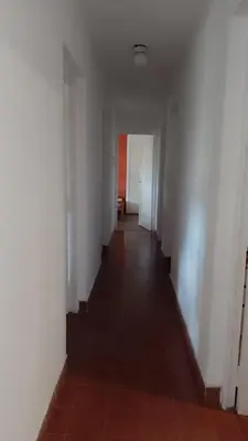 an empty hallway with white walls and a tile floor at La casita de Calamuchita in Los Reartes