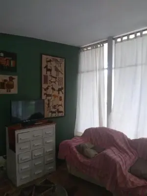 a bedroom with a bed and a dresser with a television at La casita de Calamuchita in Los Reartes