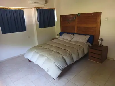 a bedroom with a large bed with a wooden headboard at Campo sereno in Falda del Carmen