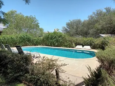 a swimming pool with two chairs at Campo sereno in Falda del Carmen