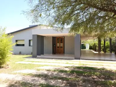 a white house with a tree in front of it at Campo sereno in Falda del Carmen