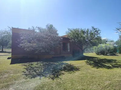 a house in the middle of a grass field at El Espinillo, Casa de Campo in Santa Rosa de Calamuchita