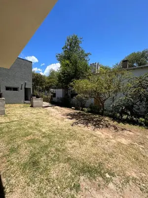 a yard with a building and a tree at Aromas del Valle in Santa Rosa de Calamuchita