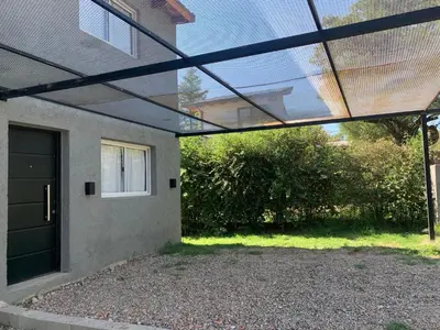 a pergola over a driveway of a house at Aromas del Valle in Santa Rosa de Calamuchita