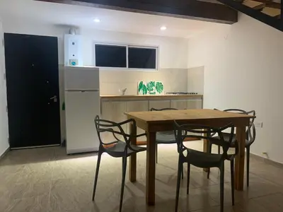 a kitchen with a wooden table and chairs at Aromas del Valle in Santa Rosa de Calamuchita