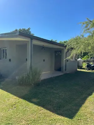 a house with a garage with a grass yard at Aromas del Valle in Santa Rosa de Calamuchita