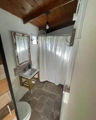 a bathroom with a toilet and a sink and a mirror at GLAMPING RANCHO ALEGRE in Merlo