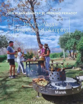 a group of people standing around an outdoor grill at GLAMPING RANCHO ALEGRE in Merlo