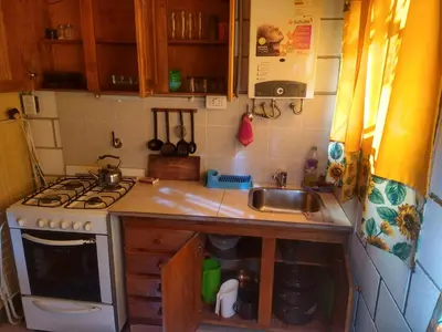 a small kitchen with a stove and a sink at Cabañas Rio y Playa in Atos Pampa