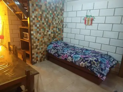 a room with a small bed in a room with tiles at Cabañas Rio y Playa in Atos Pampa