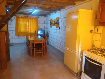 a kitchen with a table and a yellow refrigerator at Cabañas Rio y Playa in Atos Pampa