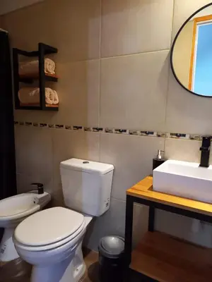 a bathroom with a white toilet and a sink at Departamento 2448 in Mina Clavero