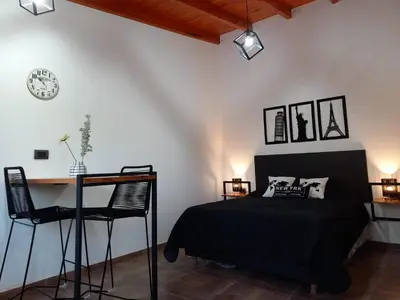 a bedroom with a bed and a desk and a clock at Departamento 2448 in Mina Clavero