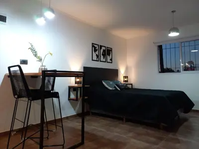 a bedroom with a bed and a desk and chairs at Departamento 2448 in Mina Clavero