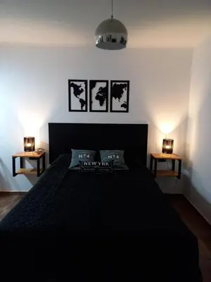 a bedroom with a black bed with two side tables at Departamento 2448 in Mina Clavero