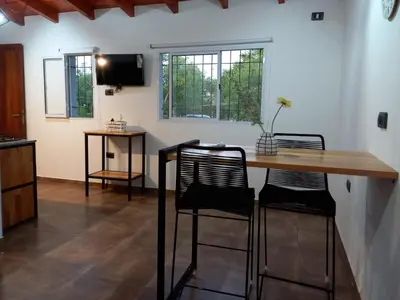 a room with a table and two chairs and a television at Departamento 2448 in Mina Clavero