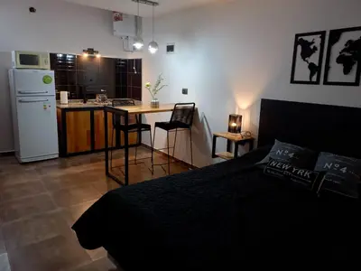 a bedroom with a bed and a kitchen with a refrigerator at Departamento 2448 in Mina Clavero