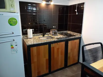 a kitchen with a sink and a refrigerator at Departamento 2448 in Mina Clavero