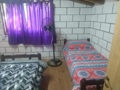 a room with two beds and a purple window at cabañas rio y playa 2 in Atos Pampa