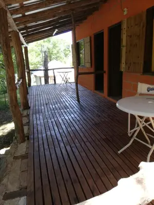 a wooden deck of a house with a table at cabañas rio y playa 2 in Atos Pampa